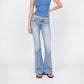 A model wearing a pink tank top and the Jane super low rise flare jeans in light indigo vintage wash from Bubblegum USA brand, front of a white background.