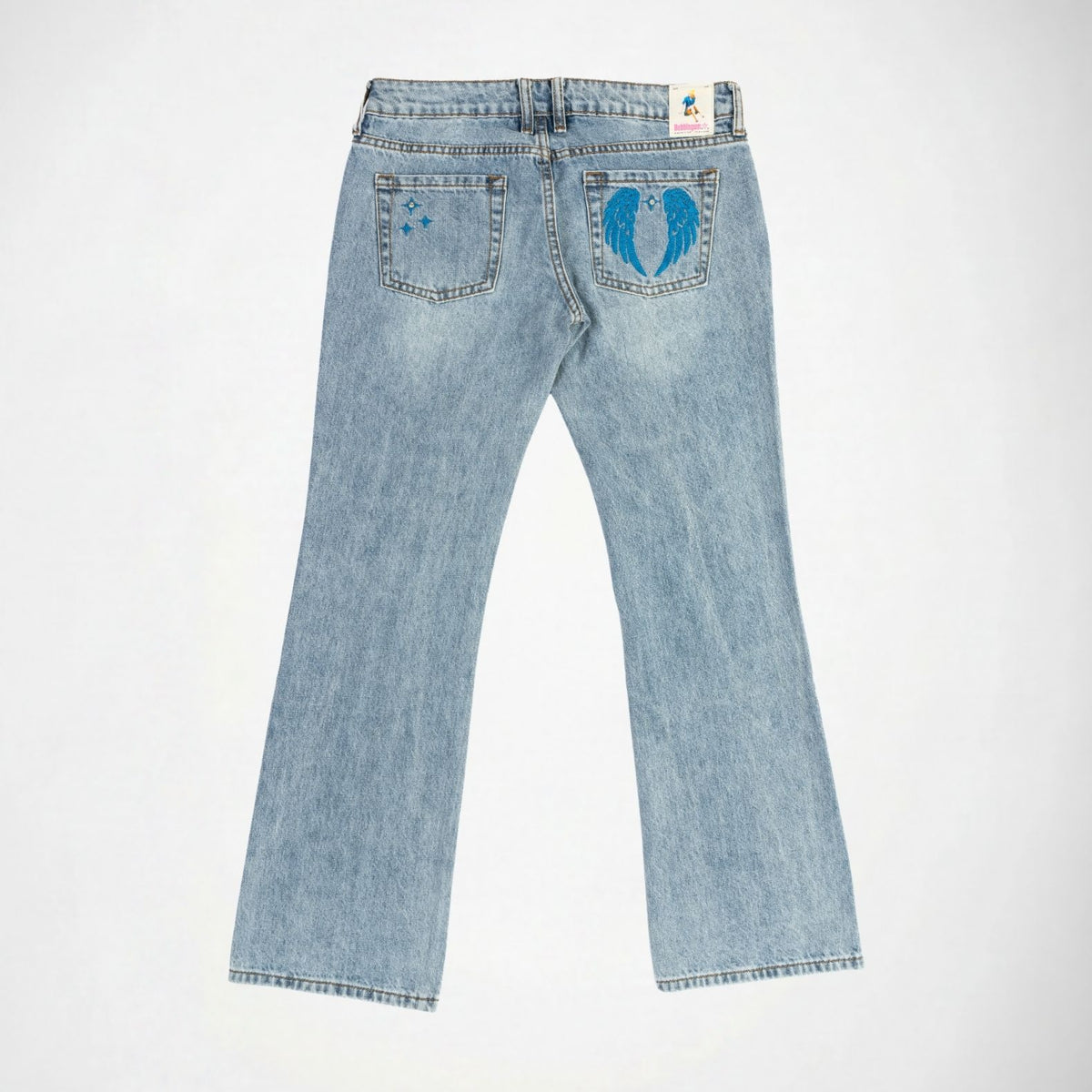 Light wash blue denim Bubblegum jeans shown from the back, featuring a blue winged star embroidery on the right pocket and blue stars on the left pocket, laid flat against a white background.