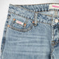 Close-up of a pair of light-wash blue denim Bubblegum jeans showing the waistband, belt loops, right pocket, and button. The fabric has a subtle vertical marbled or washed texture, and the brand name 'Bubblegum USA' is visible on the pocket label and waistband tag.