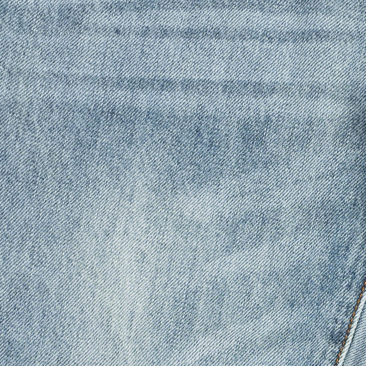A close-up of light blue denim fabric showing the detailed twill weave texture and subtle fading.