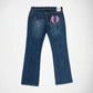 Back view of a pair of blue denim Bubblegum jeans with a pink embroidered angel wings design on the right back pocket and a small pink shining stars on the left back pocket, shown on a white background.