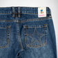 Close-up back view of blue denim Bubblegum jeans showing the waistband, belt loops, rear pockets, and a star-shaped stud embellishments made of studs on the right back pocket. A small sewn label near the waistband reads Bubblegum USA.