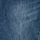 A close-up of blue denim fabric texture with a subtle diagonal twill weave and a small portion of orange contrast stitching visible at the bottom right.