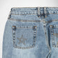 Close-up back view of light blue denim Bubblegum jeans showing the waistband, belt loops, and back pockets with decorative metallic star embellishments on a white background.