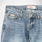 Close-up of a pair of light blue denim Bubblegum jeans showing the front waistband, button closure, pocket details, and a star embellishment on the upper left leg.