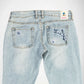Back view of light-wash blue denim Bubblegum jeans with embroidered indigo and white cherry blossom flower details on both back pockets and a visible 'Bubblegum USA' logo patch at the waistband.