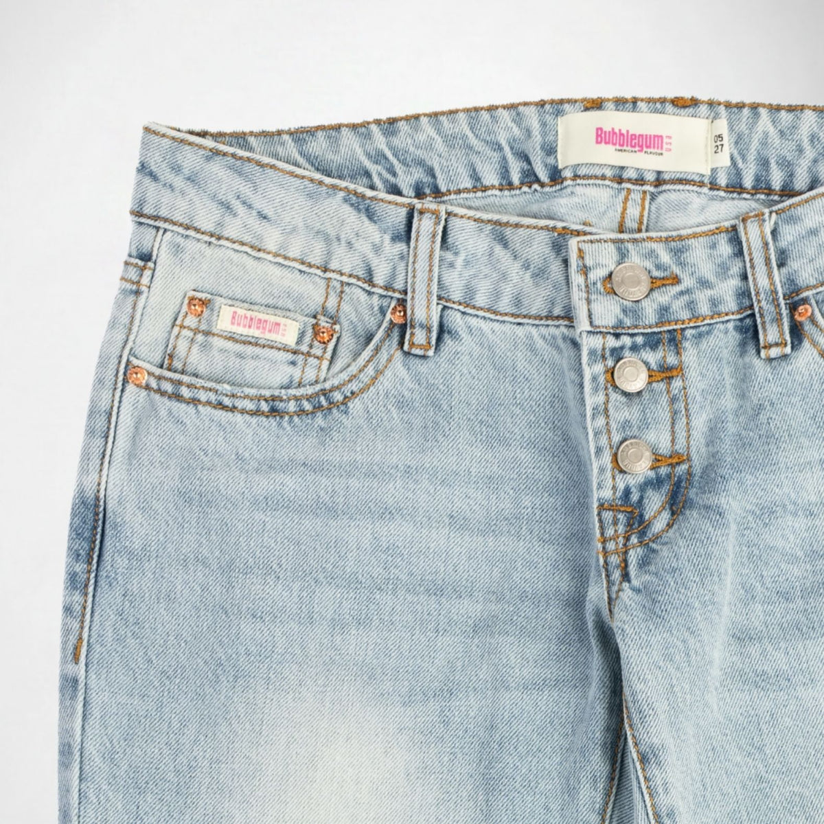 Close-up of a pair of light-wash blue denim Bubblegum jeans showing the waistband, button fly, belt loops, and front pocket details. The brand name 'Bubblegum USA' is visible on the inner waistband label and the front pocket tag.