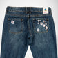 Back view of dark blue denim Bubblegum jeans featuring embroidered white and pink cherry blossom flowers on both back pockets, with a visible 'Bubblegum USA' brand label at the waistband.