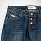 Close-up of dark blue denim Bubblegum jeans showing the waistband, button fly, front pockets, and a visible Bubblegum USA brand label.