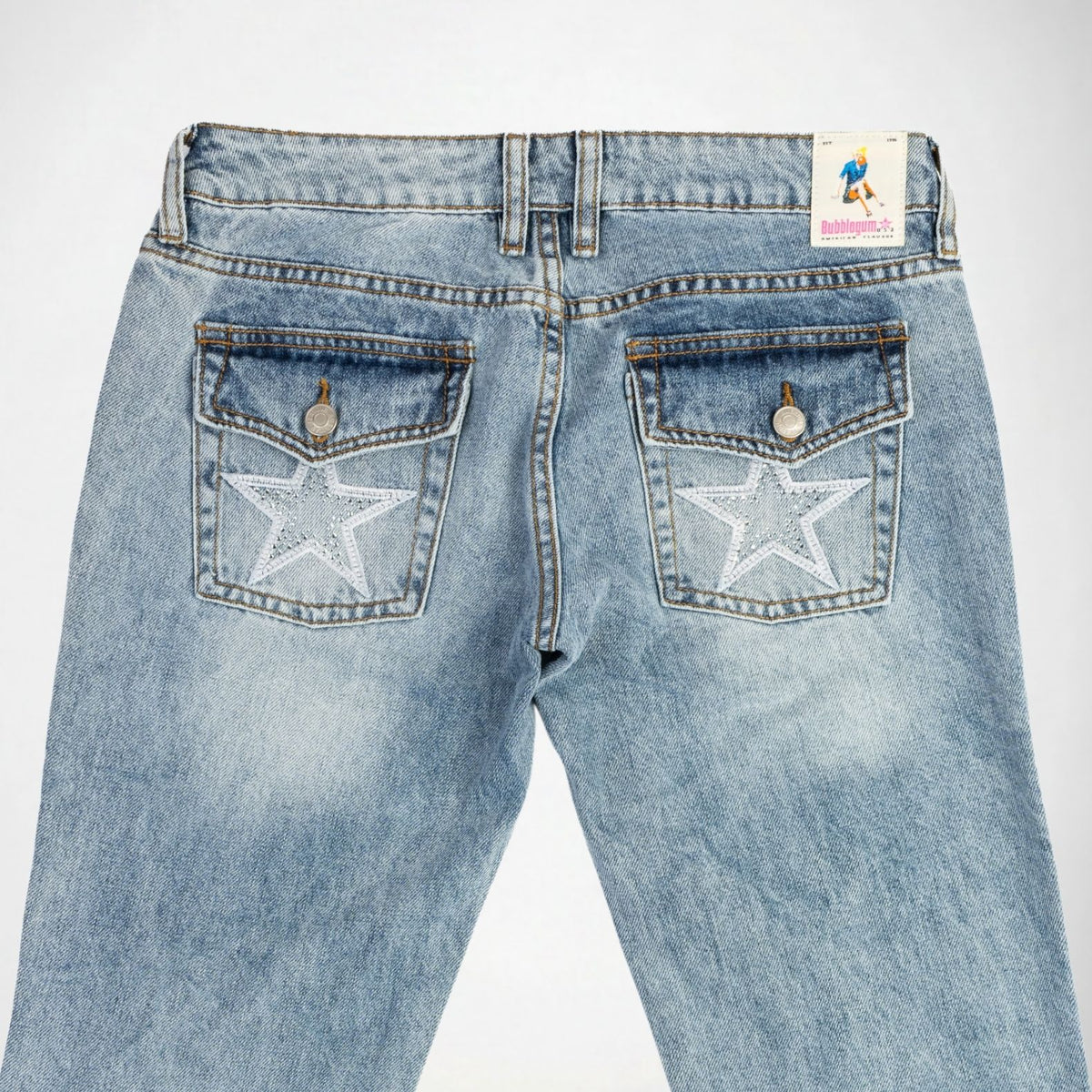 Back view of light blue denim Bubblegum jeans featuring embroidered white star-shaped with rhinestones on both back pockets, shown against a plain white background.