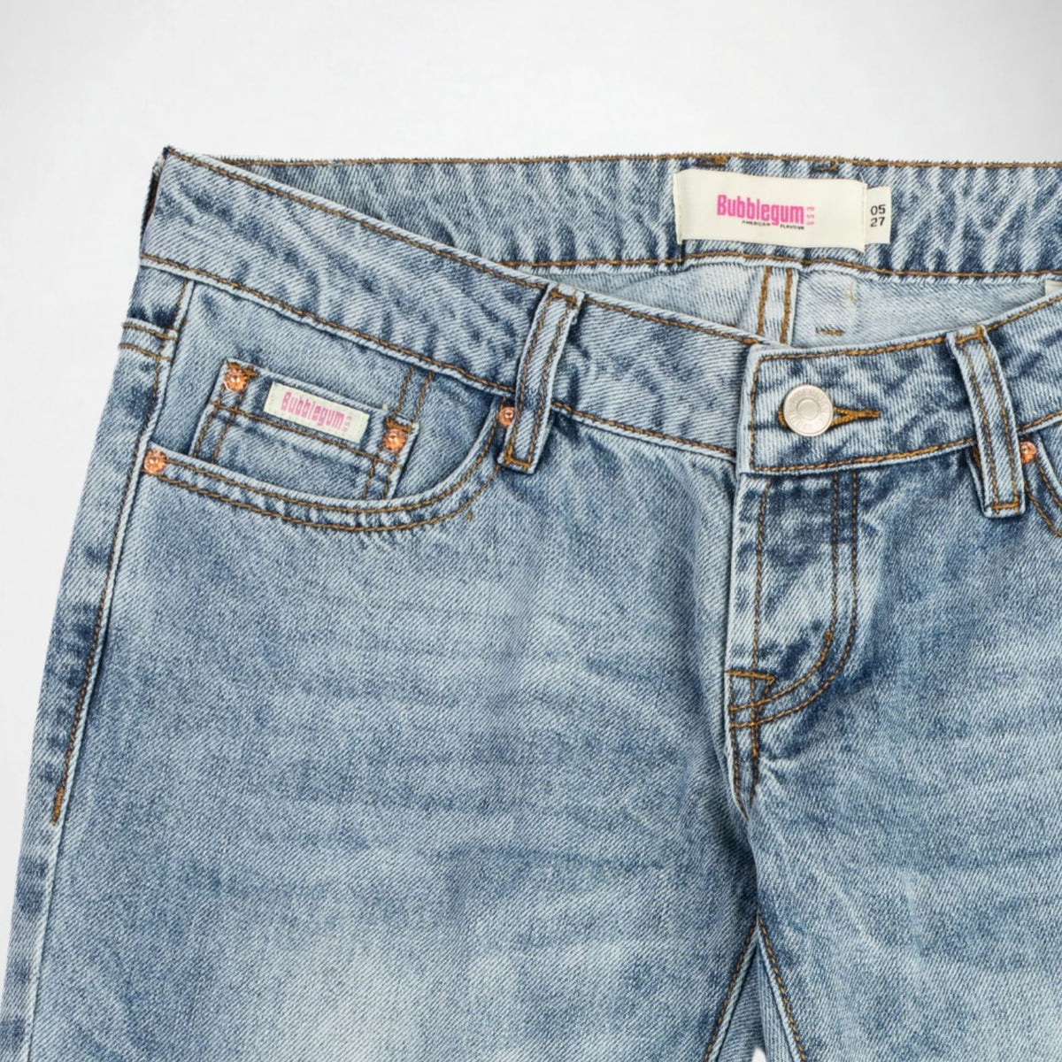 Close-up of a pair of light blue denim Bubblegum jeans showing the waistband, button, belt loops, front pocket, and inner label. The brand name 'Bubblegum USA' is visible on the waistband tag and inner pocket label.