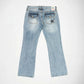 Back view of light-wash blue denim Bubblegum jeans with a star-shapped studs embellishment on the right and left back pockets, shown flat against a white background.