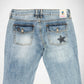 Back view of light-wash blue denim Bubblegum jeans featuring star-shaped studded embellishment details on the back pockets, photographed against a plain white background.