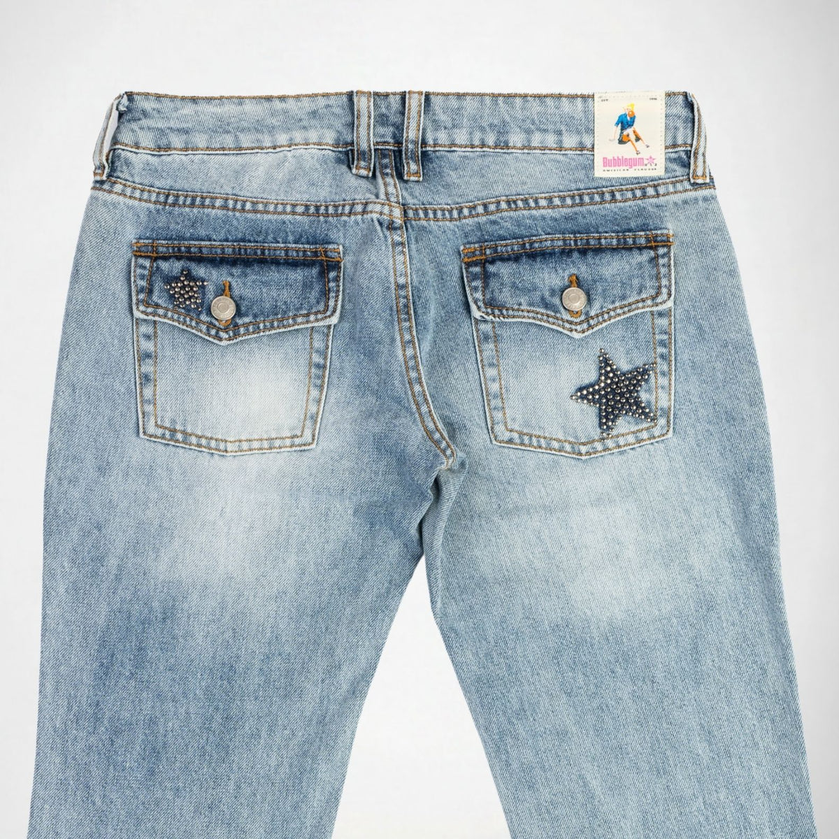 Back view of light-wash blue denim Bubblegum jeans featuring star-shaped studded embellishment details on the back pockets, photographed against a plain white background.