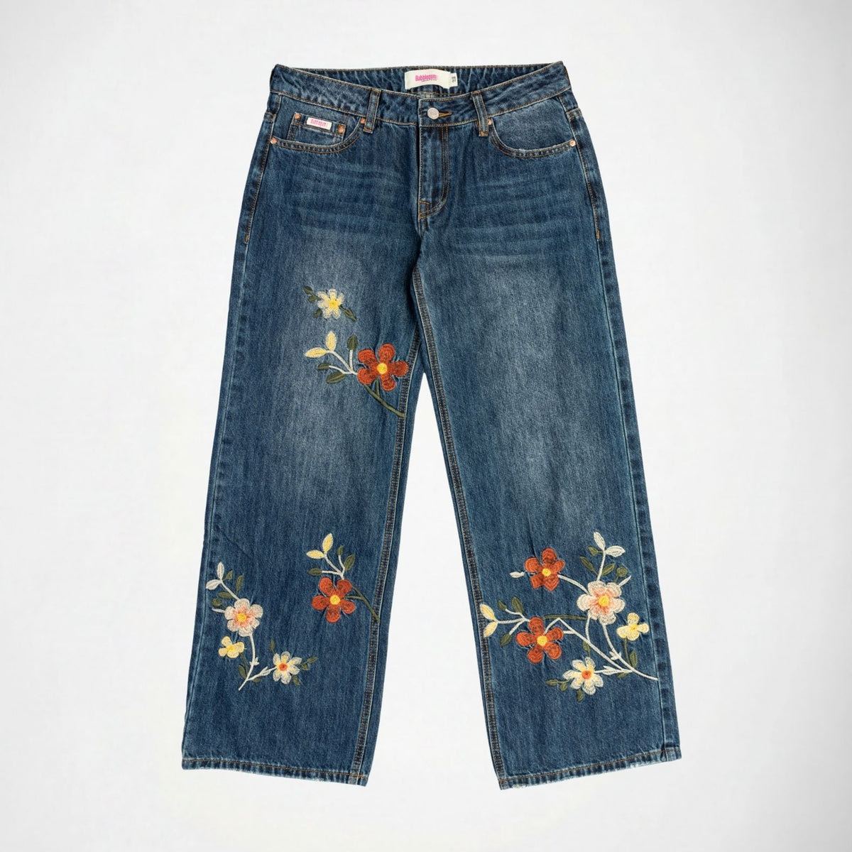 Blue denim Bubblegum jeans with colorful floral embroidery on the legs, displayed flat against a light gray background.