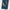 Close-up of a blue bubblegum denim garment leg with embroidered floral details in white, yellow, orange, and green on a plain light background.