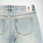 Close-up back view of light-wash blue denim Bubblegum jeans showing the waistband, belt loops, back pockets, and a visible Bubblegum USA brand patch.