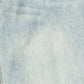 A close-up of light blue denim fabric showing the diagonal twill weave texture.
