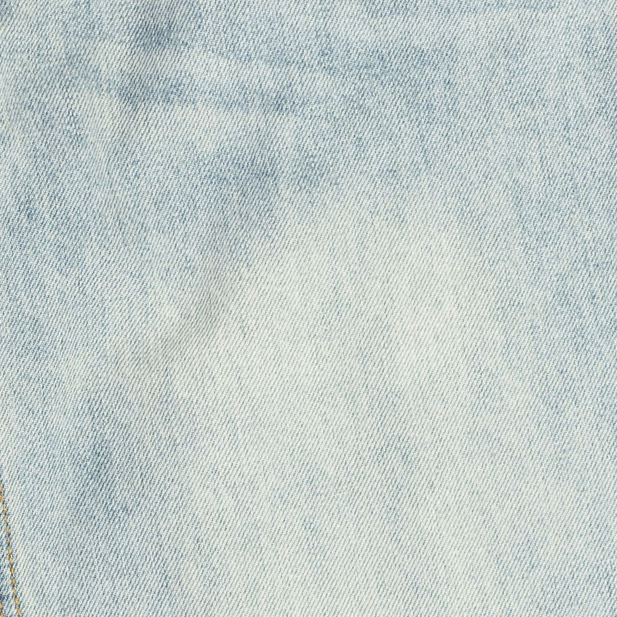 A close-up of light blue denim fabric showing the diagonal twill weave texture.