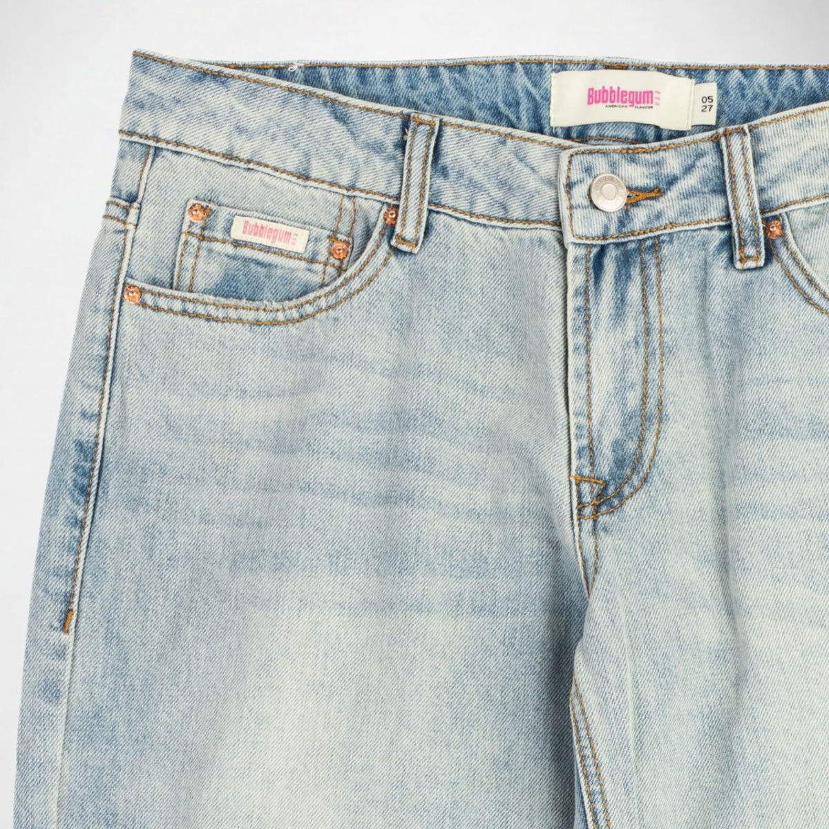 Close-up of a pair of light-wash blue denim Bubblegum jeans showing the waistband, front button closure, belt loops, pocket details, and a visible Bubblegum USA brand label.