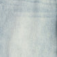 A close-up texture shot of light blue denim fabric, showing the detailed twill weave and subtle fading.