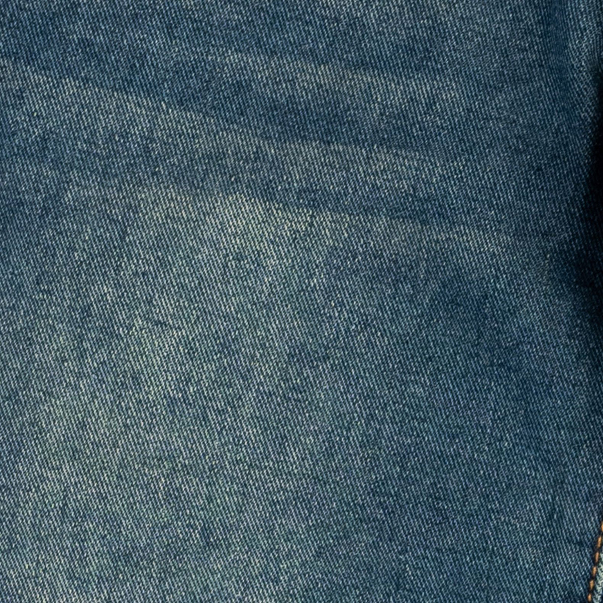 A close-up of blue denim fabric showing the woven texture and subtle fading.