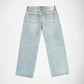 Back view of light-wash blue denim Bubblegum jeans with wings heart embroidered details with rhinestones on the back pockets, laid flat on a white background.