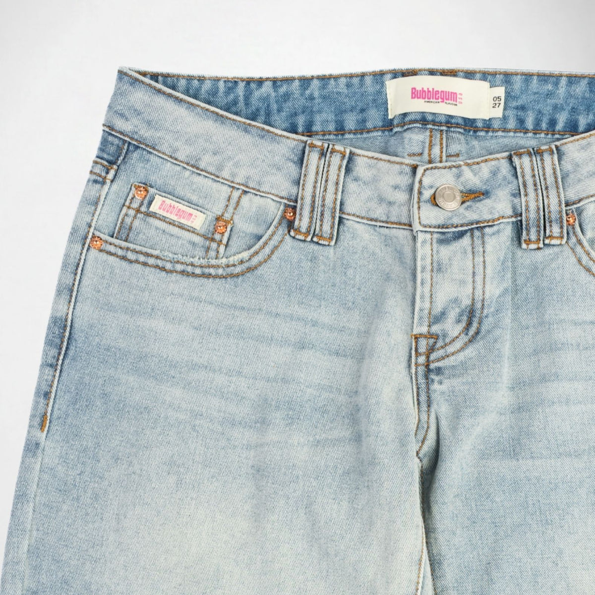 Close-up of a pair of light-wash blue denim Bubblegum jeans showing the waistband, button closure, belt loops, front pocket, and inner label.