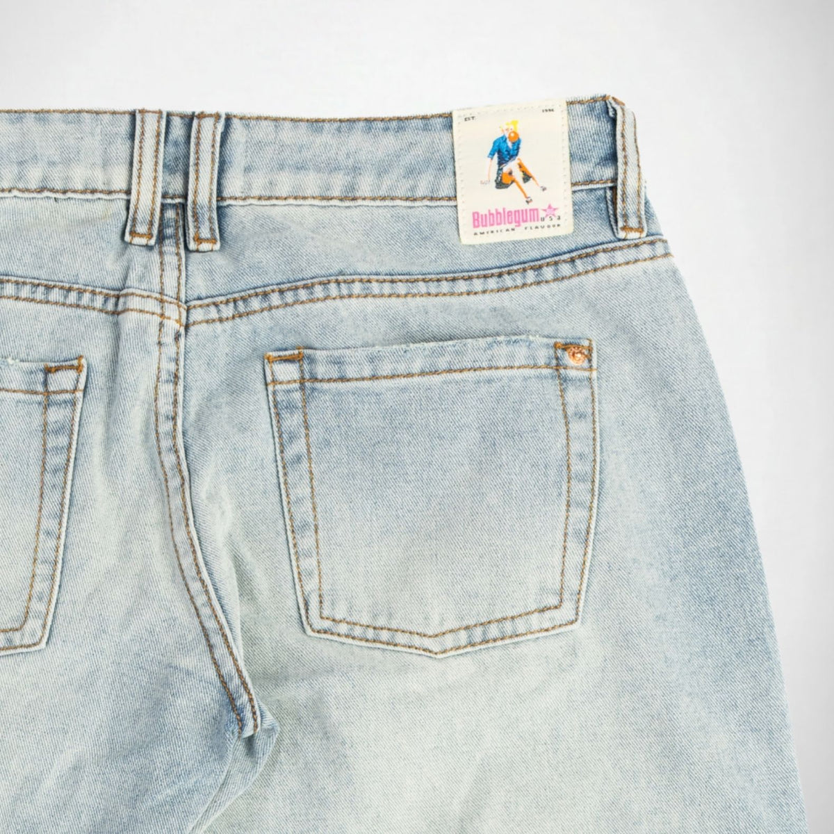 Close-up of the back waistband and rear pockets of light-wash blue denim Bubblegum jeans, showing a visible 'Bubblegum USA' brand label on the back waist.