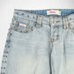 Close-up of a pair of light-wash blue denim Bubblegum jeans with silver metal studs along the side seams and pocket edges, featuring a Bubbleum USA brand label.
