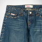 Close-up of a pair of blue denim Bubblegum jeans with silver studs embellishments along the pocket edges, orange contrast stitching, and a visible Bubbleum USA brand label.